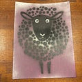 A square art print or card featuring a stylized black sheep face and body made of dots on a dusty purple background, photographed on a brown wooden surface.